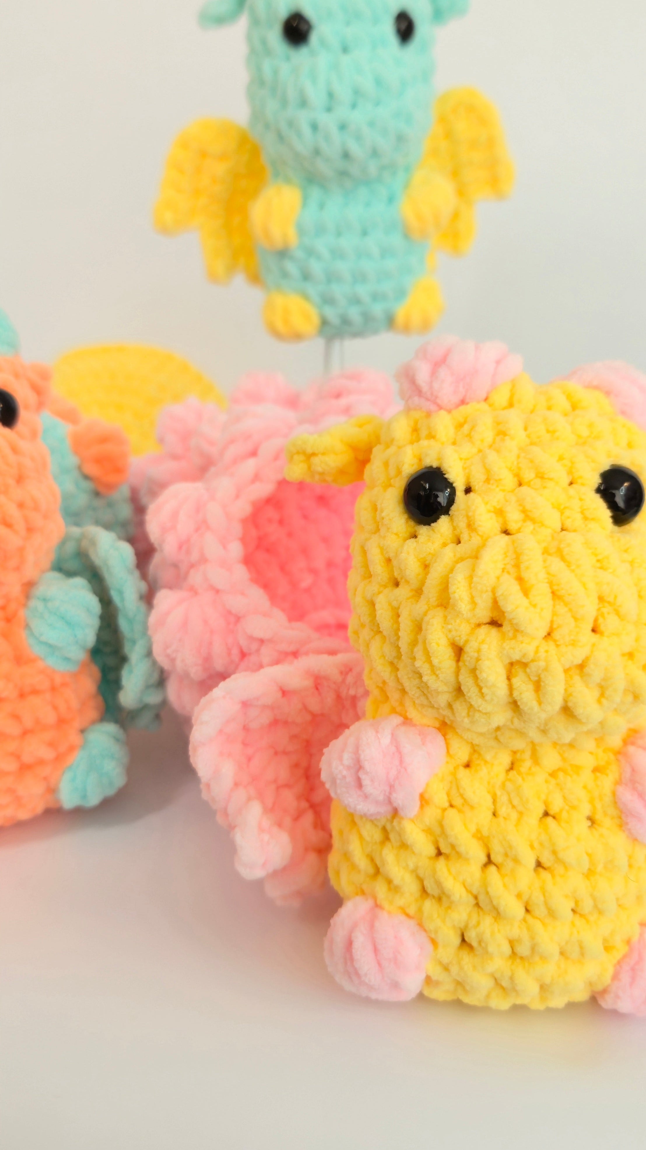 Three colorful crochet dragon toys 